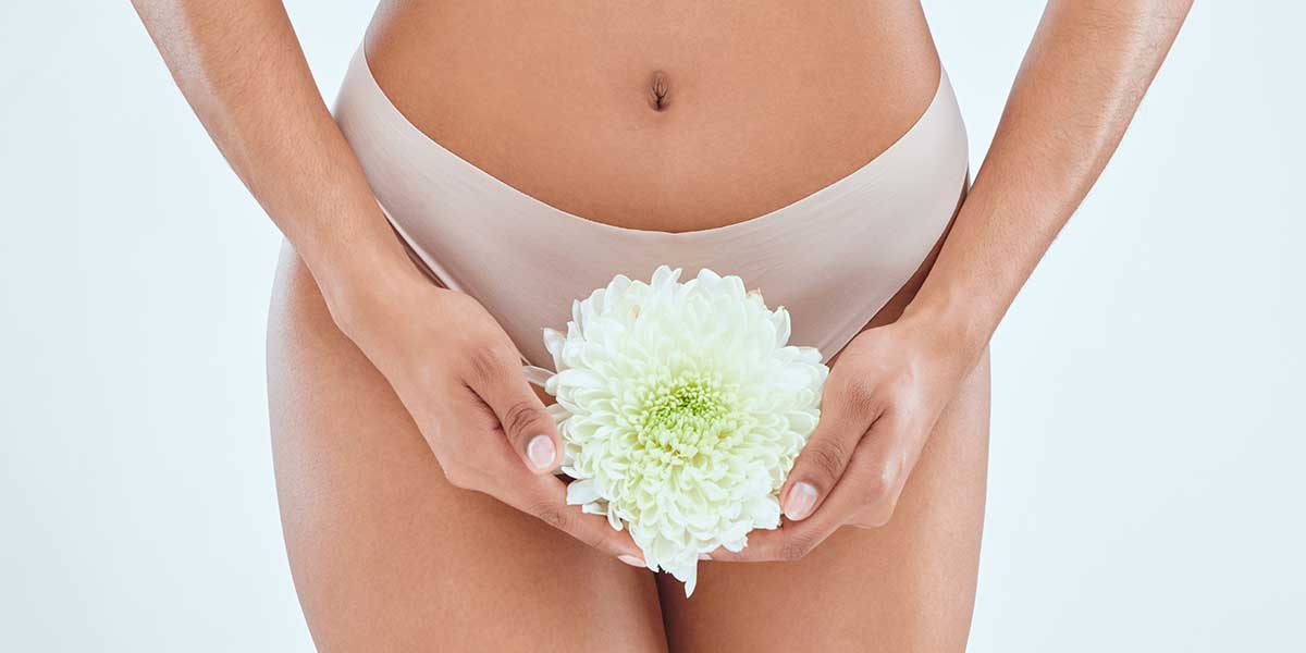 Close-up of a woman holding a white flower, representing gentle and effective FormaV vaginal rejuvenation treatments in Frisco, TX.